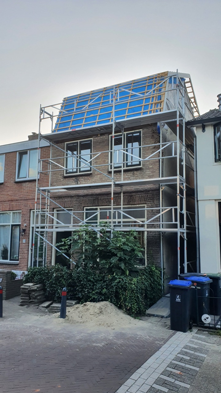 Woonhuis in Hilversum tijdens de bouw van de dakopbouw, met steiger aan de voorgevel en zichtbare dakconstructie, uitgevoerd door Bouwbedrijf Hop.
