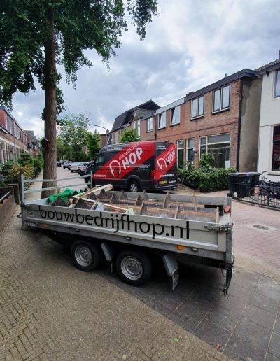 Bedrijfswagen en aanhanger van Bouwbedrijf Hop geparkeerd voor de woning in Hilversum tijdens de renovatie.