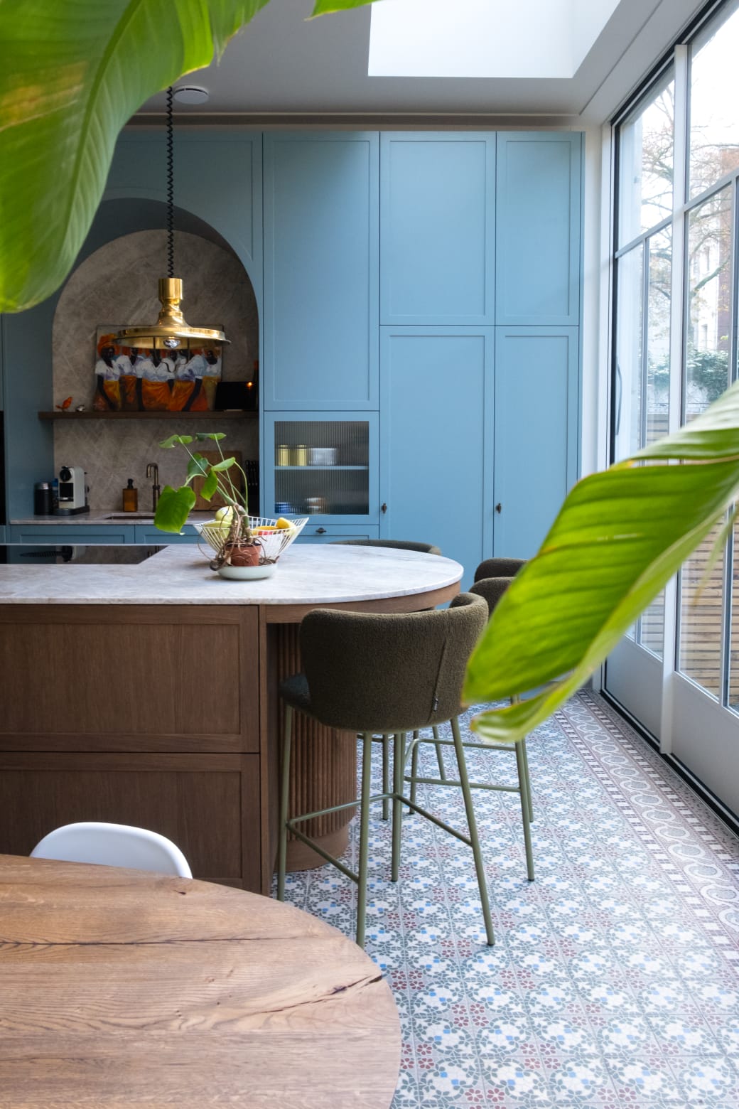 Moderne keuken na renovatie in Spakenburg met rond kookeiland, houten fronten en blauwe kastenwand