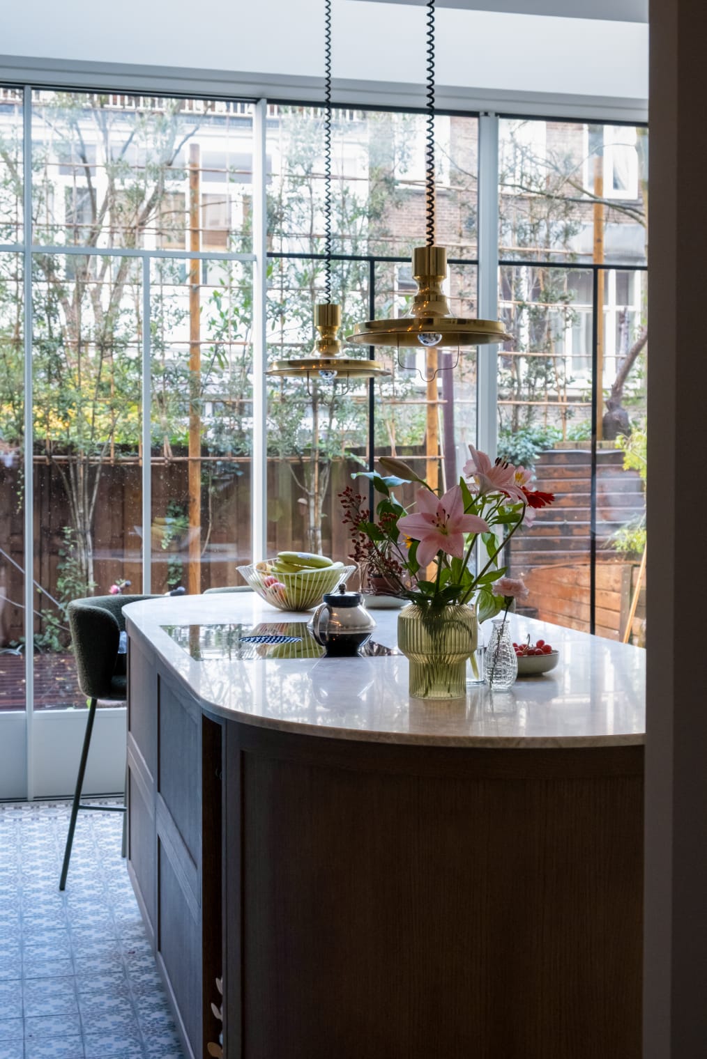 Moderne eetkamer na renovatie in Spakenburg met eettafel, bloemen en grote raampartijen met uitzicht op tuin