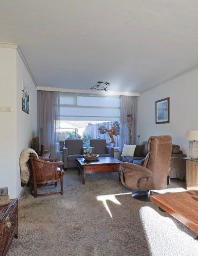 Oubollige woonkamer vóór renovatie in Spakenburg met klassieke meubels, donkere accenten en gedateerde inrichting