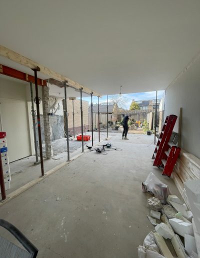 Binnenruimte tijdens renovatie in Spakenburg met bouwmaterialen, steigers en open ruimte in aanbouw